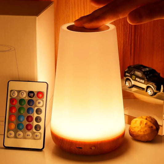 Smart RGB night light with touch and remote control, glowing softly on a wooden bedside table in a minimalist setting.