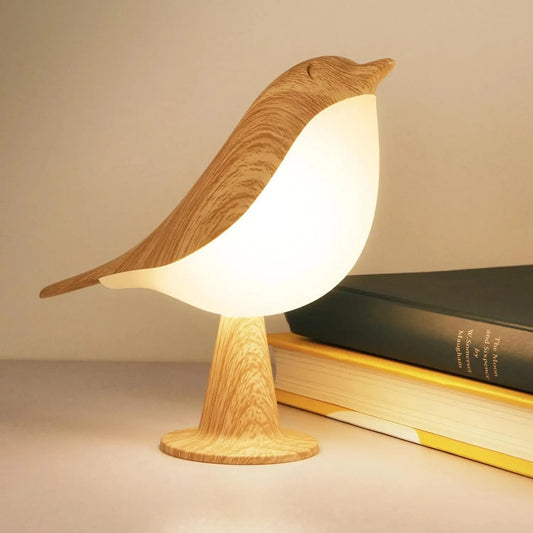 Wooden bird-shaped lamp on a surface with a book underneath